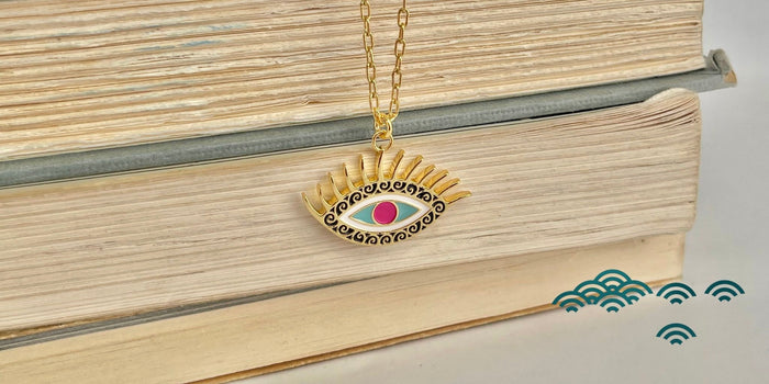 An evil eye pendant resting on top of a stack of books.